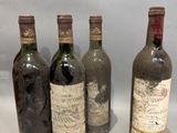 four bottles of wine are lined up on a white surface