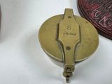a small brass object on a white surface next to other items