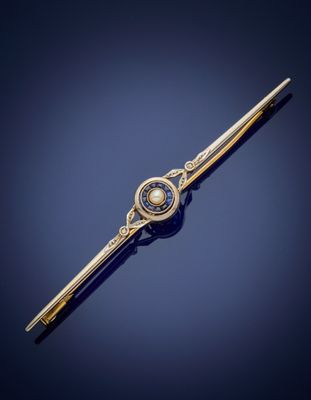 a close up of a gold and pearl tie bar on a blue background