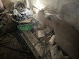 a pile of debris in a dirty room with a green basket