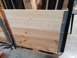 plusieurs pièces de bois sont empilées sur une palette dans un entrepôt