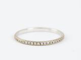 a white gold wedding band with a row of small diamonds