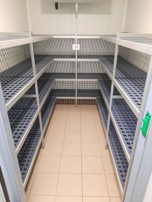 une longue étagère au milieu d'une pièce, avec des tablettes bleues