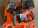 an orange tool box with a drill and two batteries on it