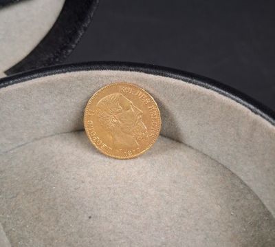 une pièce d'or posée dans une boîte sur une table