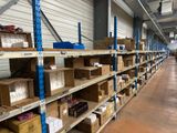 boxes are stacked on shelves in a warehouse with a man in the background