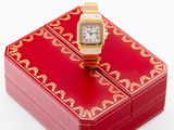 a red box with a gold watch on top of it
