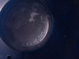 a close up of a metal object with a blue background