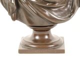 a bronze statue of a woman holding a book