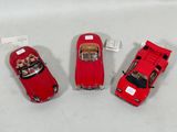 three red toy cars sitting next to each other on a white surface