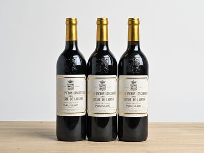 three bottles of wine sitting on top of a wooden table