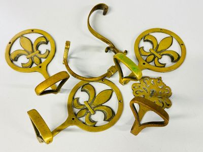 four antique brass wall hooks with fleurons and flowers on them