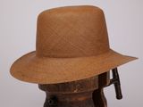 un chapeau marron posé sur un support en bois