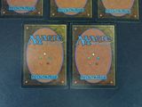 four decks of magic the gathering are shown on a black surface