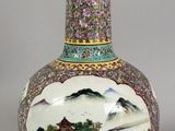 a vase with a painting on it sitting on a table