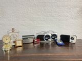 many different clocks and other items on a wooden table