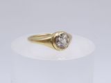 a close up of a gold ring with a diamond on it