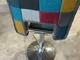 a chair that has a colorful patchwork seat on it