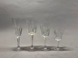 quatre verres à vin sont alignés sur une surface blanche