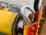 a close up of a yellow pipe on the side of the road