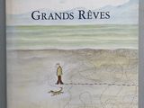 un livre sur lequel figure la photo d'un homme promenant son chien sur la plage