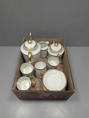 a box with a variety of white and gold dishes