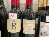 several bottles of red wine are lined up on a counter