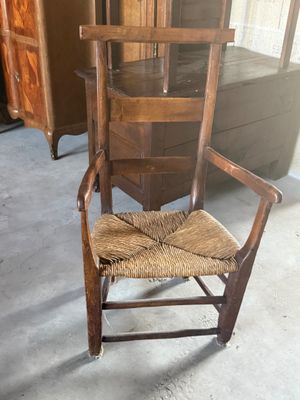 une chaise en bois avec une assise marron dans une pièce