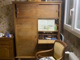 a room with a desk, chair, and a cabinet in it