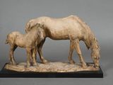une statue représentant un cheval et un poulain posée sur une table