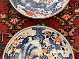 two plates that are sitting on a red rug