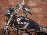 a black motorcycle parked in front of a brick wall