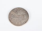 a close up of a coin on a white surface with a white background