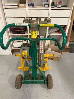 un diable vert muni d'une poignée verte et d'une poignée jaune