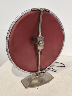 une image représentant un objet rouge et argenté sur une surface blanche