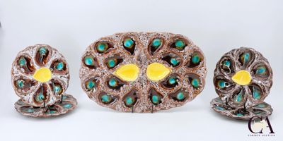trois pièces de poterie ornées de motifs en turquoise et en or sur fond blanc