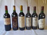six bottles of wine are lined up in a row on a table