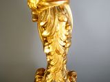 a gold statue of a man holding a fish on a marble base