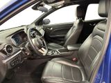 the interior of a blue car with leather seats and a steering wheel