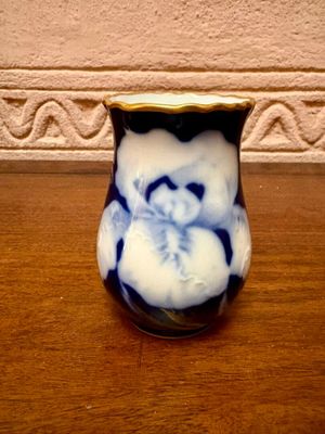a blue and white vase sitting on a wooden table