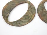 pair of green and brown wooden hoop earrings on a white surface