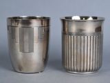 deux tasses en argent posées l'une à côté de l'autre sur une table
