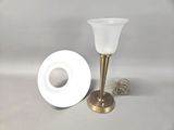 a white vase and a gold candle holder next to each other