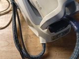 a white and blue steam iron on a wooden table