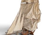 a small model of a sailboat on a white surface
