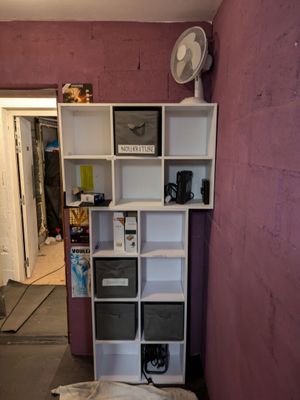a room that has a bed and a book shelf in it