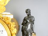 a statue of a woman holding a bag next to a clock
