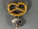 a pretzel shaped brooch with rhines on it
