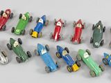 de nombreuses petites voitures miniatures alignées sur une surface blanche