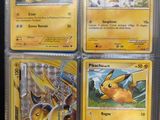 four pokemon cards are in a plastic case on a table